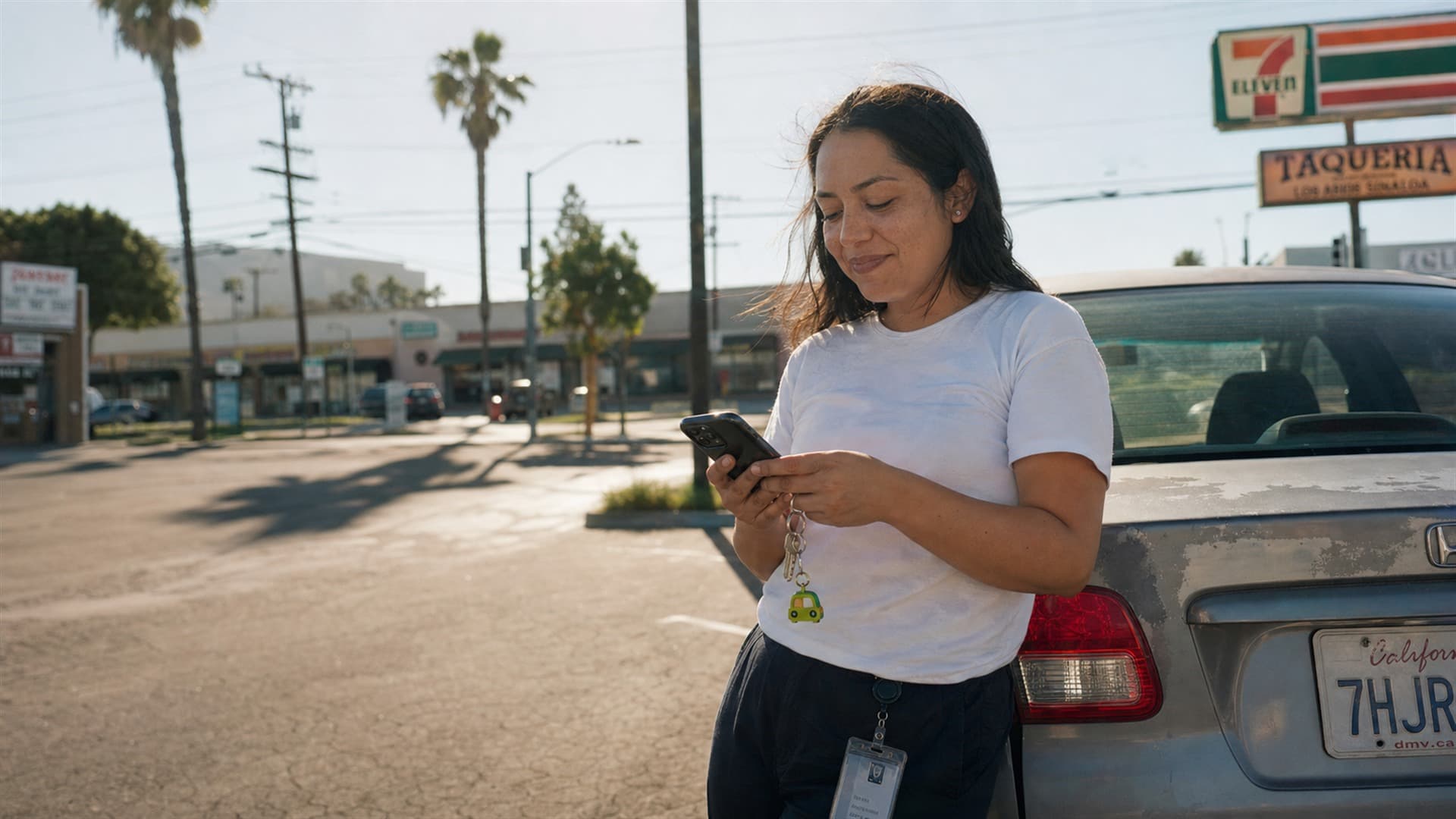 California driver checking her phone beside her car near a local 7-Eleven
